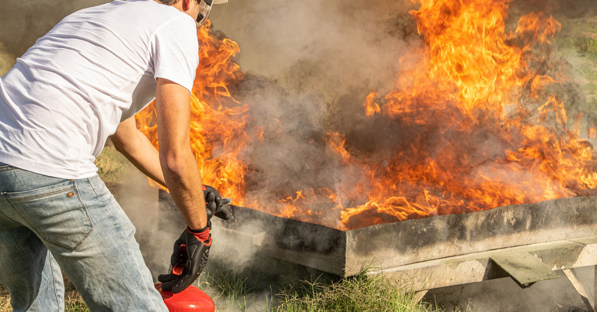 Un technicien incendie teste un extincteur sur des flammes